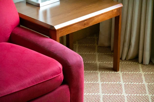 木製のサイドテーブルの横にある赤い椅子 — ストック写真
