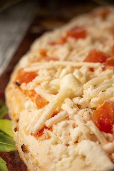Frozen margarita pizza close up with cheese and diced tomatoes