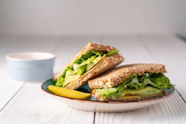 Avokado peyniri ve turşulu marullu sandviç.