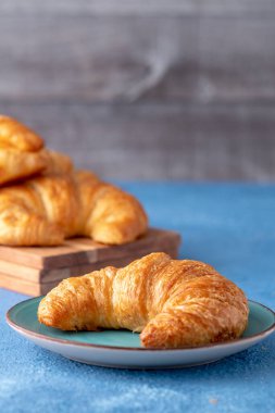 Mavi arka planlı gevrek taze kruvasan ruloları.