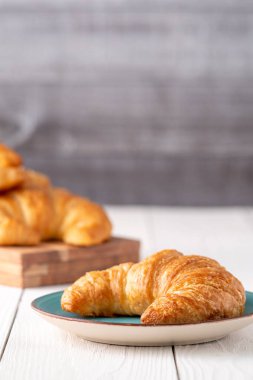 Mavi arka planlı gevrek taze kruvasan ruloları.