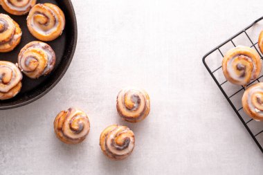 Ev yapımı tarçınlı rulo, soğutma rafında soğutulmuş demir tavada pişirilmiş, kremalı.