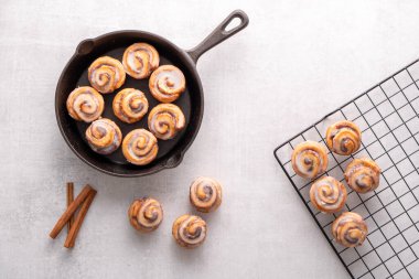 Ev yapımı tarçınlı rulo, soğutma rafında soğutulmuş demir tavada pişirilmiş, kremalı.
