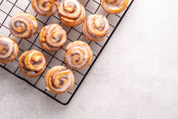 Homemade baked cinnamon rolls on cooling on cooling rack