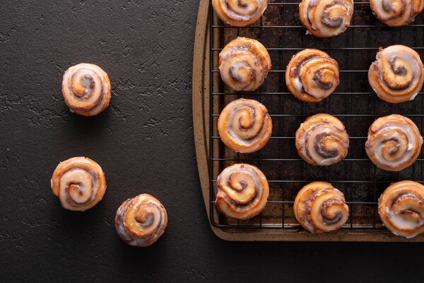Homemade baked cinnamon rolls baked in a cookie sheet with icing.