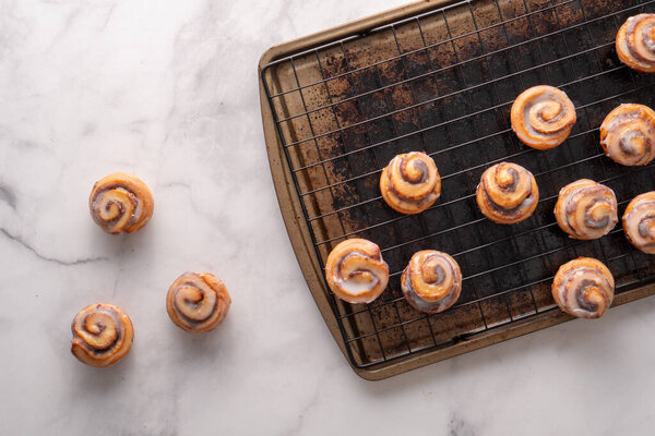 Homemade baked cinnamon rolls baked in a cookie sheet with icing.