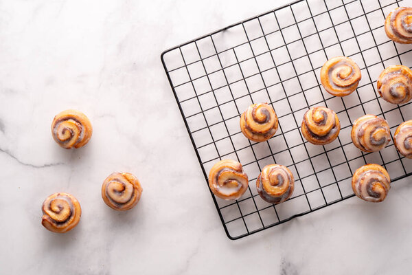 Homemade baked cinnamon rolls on cooling on cooling rack