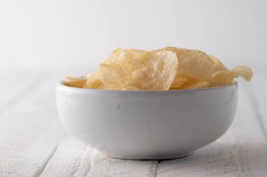 Bir kasede patates cipsi yığılıyor.