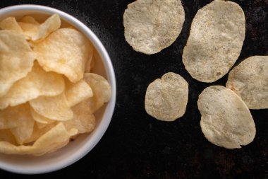 Bir kasede patates cipsi yığılıyor.