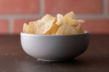 Bir kasede patates cipsi yığılıyor.