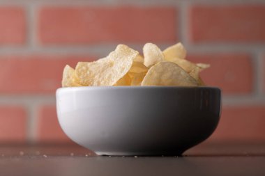 Bir kasede patates cipsi yığılıyor.