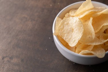 Bir kasede patates cipsi yığılıyor.