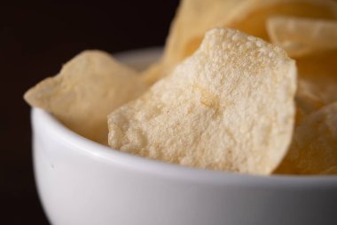 Bir kasede patates cipsi yığılıyor.