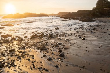 Pasifik Okyanusu 'nun çekilmekte olan gelgiti üzerinde sıcak gün batımı