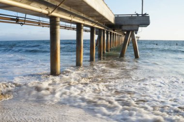 Venedik sahilindeki rıhtımın altında dalgalar çarpışıyor.