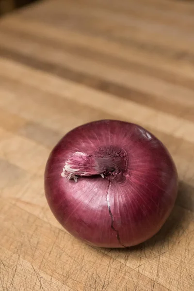 Closeup Shot Red Unpeeled Onion Bulb Wooden Board — Stock Photo, Image