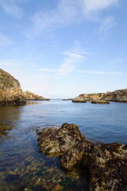 Dalgalar kayaları açığa çıkarır ve sakin okyanus suları ve gelgit havuzları oluşturur.