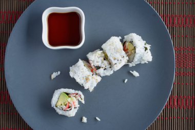 Yukarıdan oyulmuş suşi, soyanın yanında gri tabakta yatıyor. 