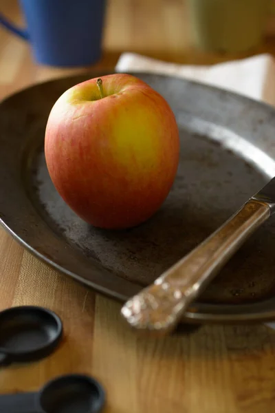 A red Fuji apple on a plate