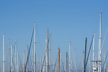 Yelkenli gemi direkleri açık ve kalabalık bir şekilde limana yanaşmış.