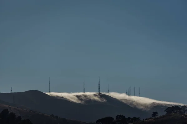 尾根上の電気通信塔上の霧のロール — ストック写真