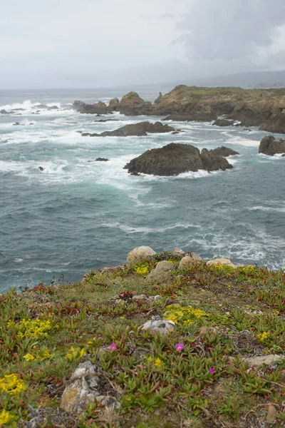 海の荒波の中で岩を眺めながら緑の崖の海岸線の風景 — ストック写真