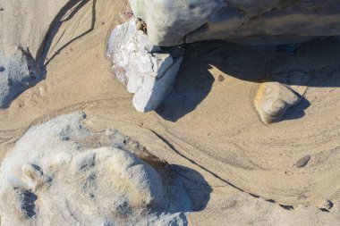 Güneşli bir günde kayaların ve kumların üzerinden