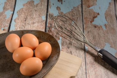 Kırsal metal bir plaka, 6 'lı kahverengi yumurta, bir tutam ve kesme tahtası..