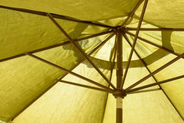 Sarı tekstil plaj şemsiyesinin güneş altında kahverengi çelik manzarası