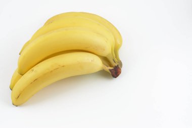 Beyaz arka planı olan bir grup sarı muz..