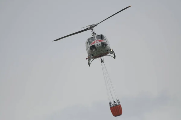 一架卡尔消防直升机在美国加州贝瑞萨湖带着水桶四处飞行 — 图库照片