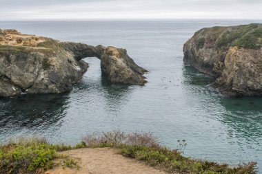 Okyanus suyunda lagün oluşturan kemerli uçurumların manzarası 