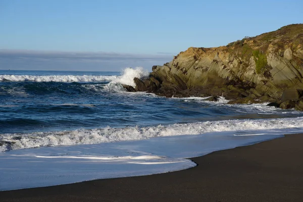 Δυνατά Κύματα Θάλασσας Κυλούν Στην Αμμώδη Ακτή Κοντά Βραχώδη Γκρεμό — Φωτογραφία Αρχείου