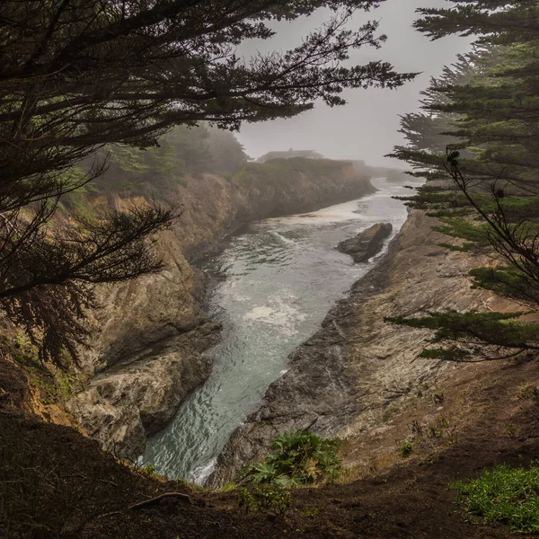 灰色の日に石の崖の間を流れる水の流れの素晴らしい景色 — ストック写真