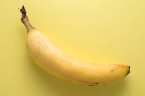 未剥皮的香蕉黄背景 — 图库照片