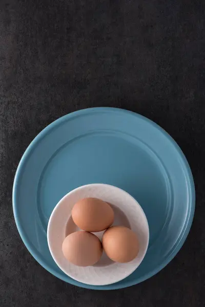 Bruine Eieren Witte Schaal Blauw Bord Zwart Oppervlak — Stockfoto
