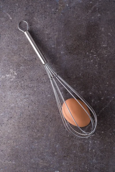 Brown Egg Trapped Caged Wire Whisk Rustic Stone Surface — Stock Photo, Image