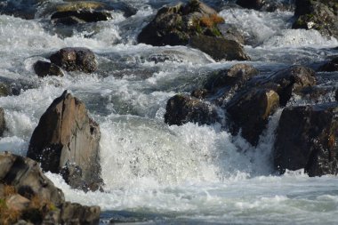 Tüketim nehri kayaların üzerinden hızla akıyor