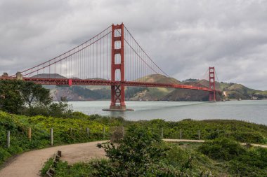 Gri bulutlu bir günde, kanal suyunun üzerindeki Golden Gate köprüsünün manzarası.