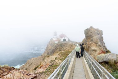 İnsanlar yoğun bir sis ile Point Reyes fenerine doğru merdivenlerden iniyor..