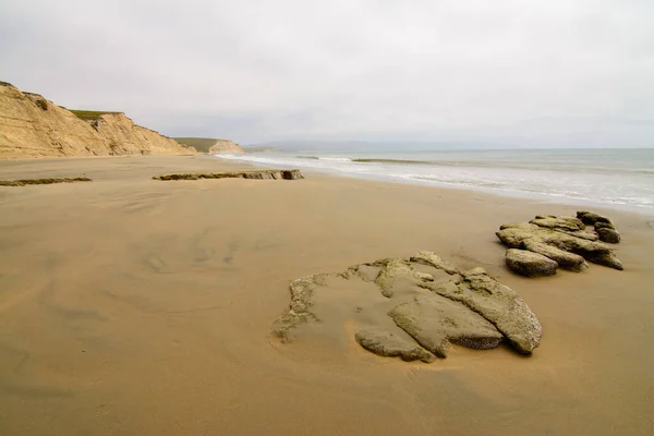 Sakin Bir Günde Bulutlu Bir Günde Kayaları Dalgaları Kaplayan Kumsal — Stok fotoğraf