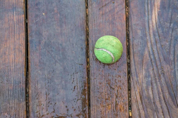 Góry Ujęcie Starzejącej Się Brudnej Piłki Tenisowej Mokrej Drewnianej Podłodze — Zdjęcie stockowe