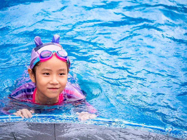 身穿泳衣的亚洲儿童或女童在游泳池学习 在踢踏板上学习和训练游泳 — 图库照片