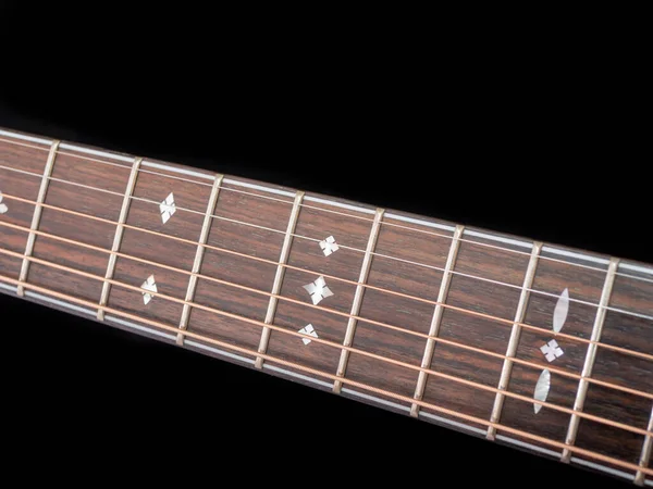 暗い背景に6弦のアコースティックギターの首 黒を基調としたギターネック 6弦アコースティックギターの木の首 ギターの指板 選択的焦点 — ストック写真