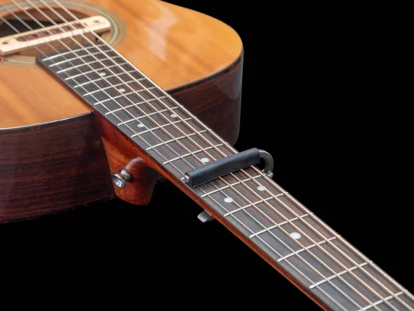 アコースティックギターネックのカポ アルミ製のカポ カポでの選択的フォーカス 黒の背景 — ストック写真