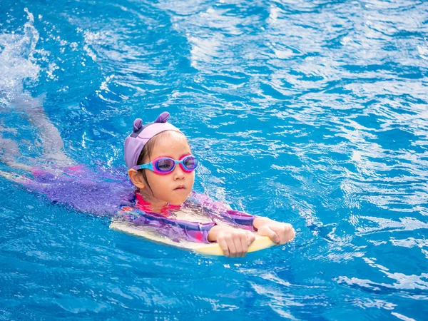 アジアの子供や子供の女の子は スイミングプールで学ぶために水着を着て キックボード上で学び 訓練泳ぐ — ストック写真