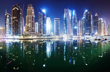 Gece Dubai Limanı 'ndaki gezinti ve kanallarda lüks gökdelenler, Birleşik Arap Emirlikleri
