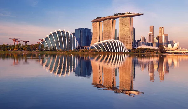 Singapur şehrinin panoraması, güneş ışığı ve su üzerindeki yansıma mimarisi ile gündoğumunda iş merkezinin modern inşaat alanında yükselişte.