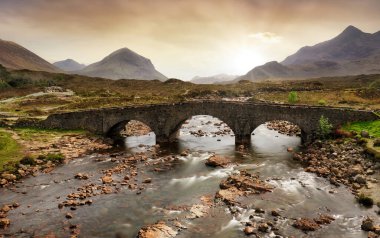İskoçya 'nın Skye Adası' ndaki Black Cuillin dağlarının güzel manzaralı Sligachan Eski Köprüsü.