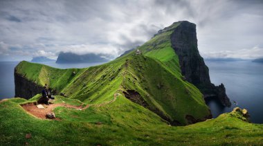 Kallur deniz feneri günbatımında Kalsoy adasının yeşil tepelerinde, Faroe Adaları, Danimarka. Peyzaj fotoğrafçılığı